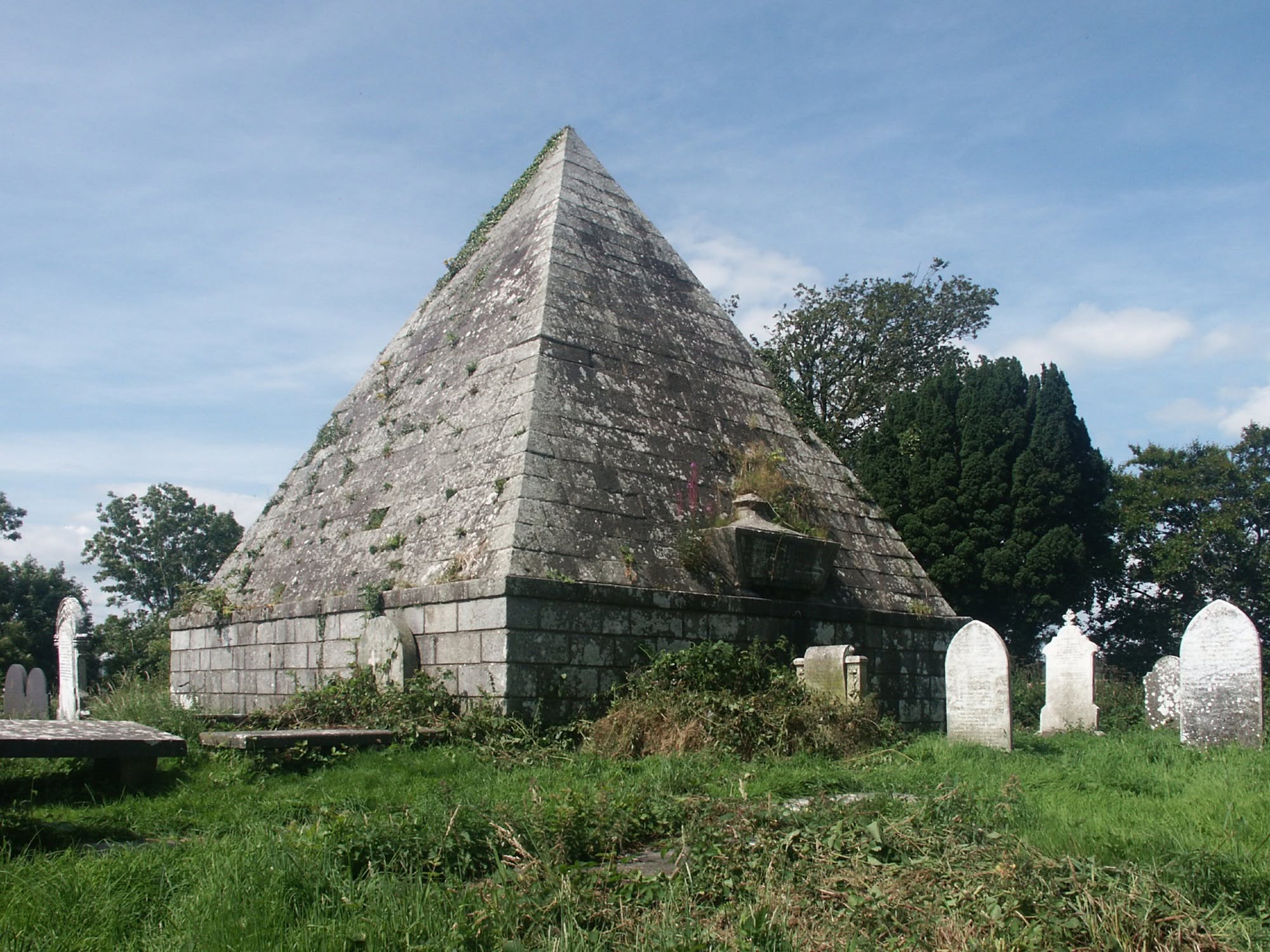 A large stone pyramid monument surrounded by gravestones in an Irish graveyard